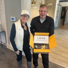 two people smiling and holding an opened box